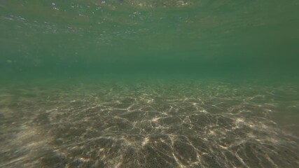 Under the shallow sea surface at Pedn Vounder Beach, South Cornwall, England on a sunny June day.