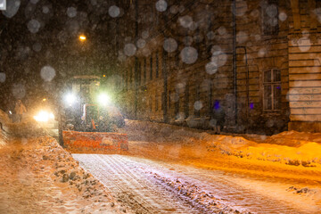 Obraz premium Snowplow Tractor Clearing Streets during Winter Blizzard in Lviv