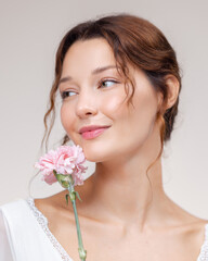 Elegant Woman With Pink Flower Smiling in White Lace Dress