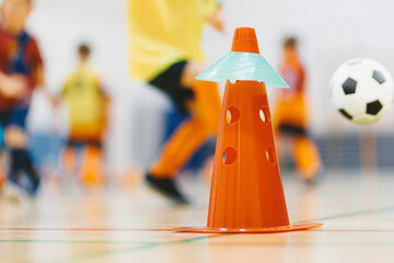 Indoor Youth Soccer Drill With Cones. Football Training Equipment and Kids Practicing in Sports Hall