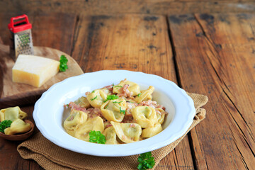 Tortellini in Schinken Sahne Sauce mit freiraum im Hintergrund
