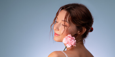 Elegant Woman With Closed Eyes Holding Pink Flower Against Blue Background