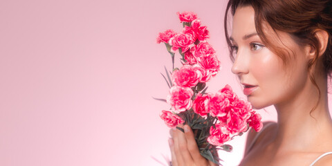 Beautiful Woman Holding Pink Carnations in Soft Romantic Lighting