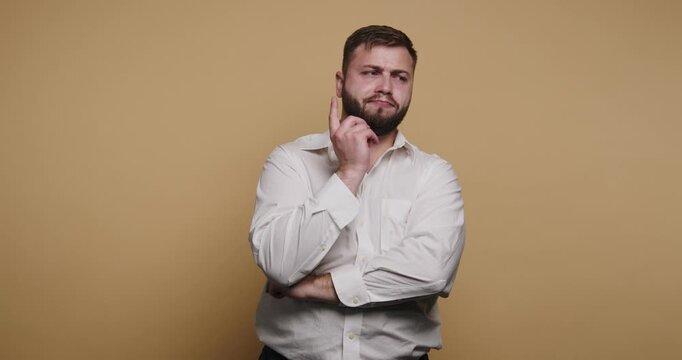 Man poses thoughtfully in front of a yellow background during a casual moments