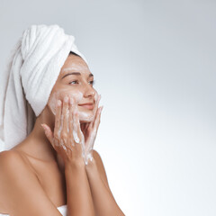 Smiling Woman Washing Face with Cleanser Foam in Skincare Routine Shot