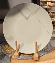 Grupo de platos con l&iacute;neas doradas en expositor en estante de comercio	