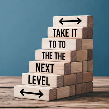 "Wooden block staircase with motivational phrase TAKE IT TO THE NEXT LEVEL"