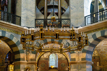 Interior of historic cathedral featuring large ornate chandelier, marble arches and decorative patterns. Sacred architecture background suitable for religion, culture, travel and heritage themes. © Инна Мадеева