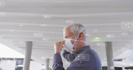 Adjusting senior man in collared shirt fixing white N95 mask on platform, glasses, copy space