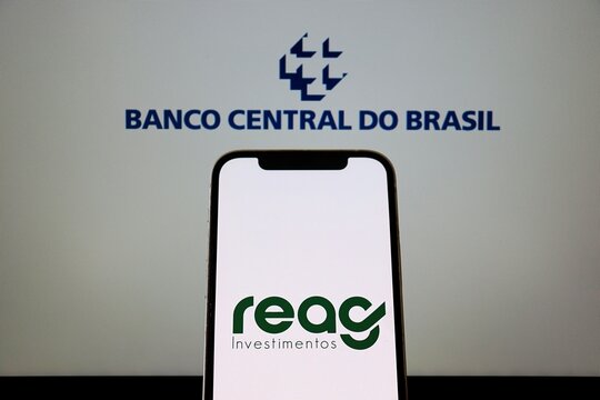 Salvador, Brazil - January 15, 2026: REAG Investimentos logo and Banco Central do Brasil logo on  smartphone screen. Reag logo.