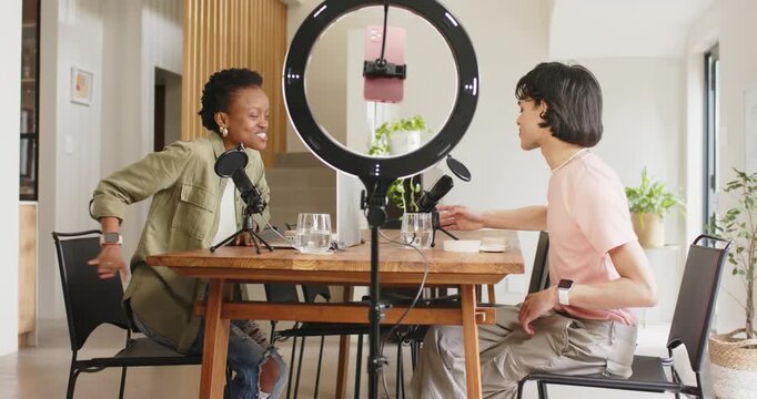 When recording starts diverse podcasters leaning in studio adjusting mics discussing episode topics