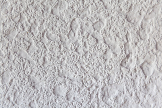 Primer plano de pared blanca de estuco o yeso con textura irregular, hendiduras y acabado mate.Primer plano de pared blanca de estuco o yeso con textura irregular, hendiduras y acabado mate.