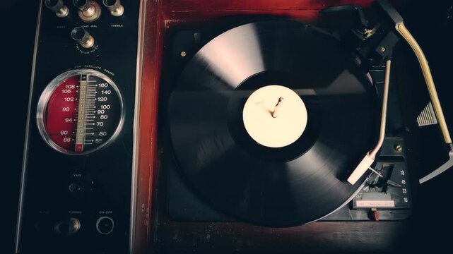 Wide shot of a vinyl record with a white label being played on a vintage classic turntable sound system. LP music album on a record player.