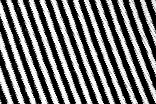 High-contrast diagonal zigzag stripe pattern with a textured fabric appearance, isolated on a transparent background. - Powered by Adobe