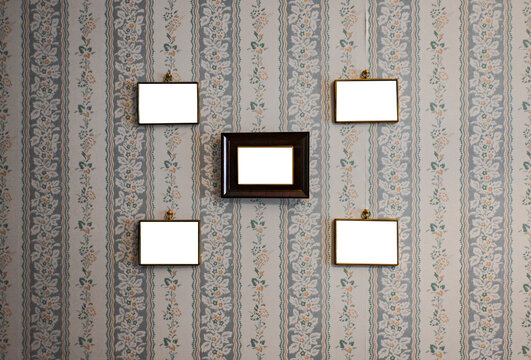 Blank vintage frames on old wallpaper room