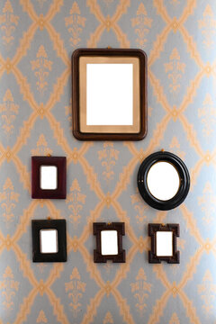 Blank vintage frames on old wallpaper room