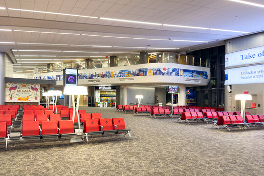 New York, USA - March 29th, 2024: Spacious Terminal B lounge area with red priority seating featuring wheelchair symbols in renovated LaGuardia airport interior
