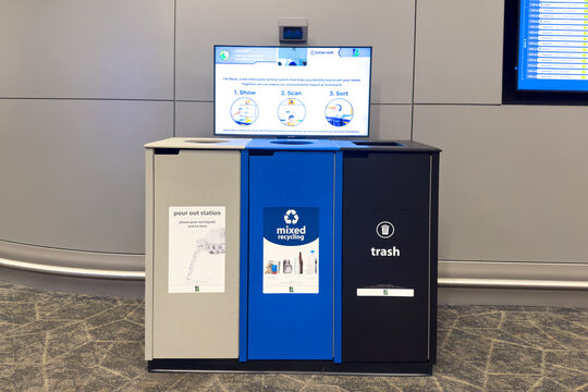 New York, USA - March 29th, 2024: Smart waste sorter in Terminal B with large interactive screen pour out station for liquids and separate recycling trash compartments