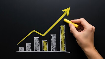 Hand drawing a rising bar graph with an upward trend line on a blackboard.