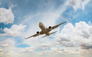 Obraz premium White passenger airplane flying in the sky amazing clouds and snowy mountains in the background - Travel by air transport