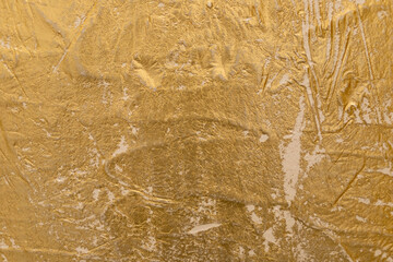 Close-up view of a golden textured Venetian plaster surface showcasing intricate patterns, ideal for backgrounds, design inspiration, or adding an elegant touch to visual projects.