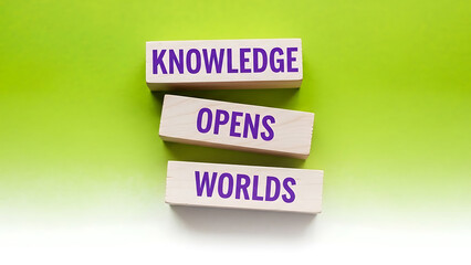 Knowledge opens worlds with wooden blocks on green background