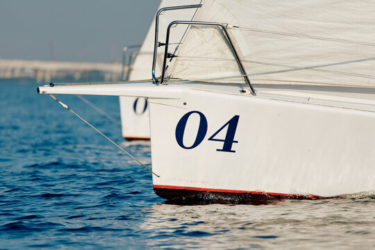 bow of a sailing boat with bowsprit at sailing regatta in the Gulf of Finland at sunny day, sailing yacht competing in a race, splashing water from under the boat, teamwork, board the boat