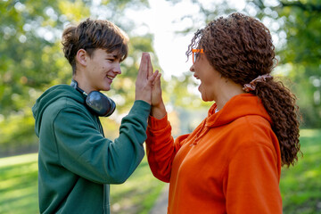 Friends enjoy a fun game of high five in a sunny park during afternoon hours
