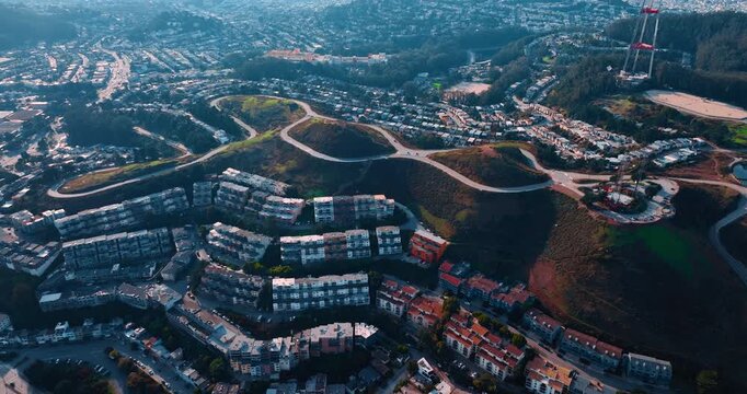 Rising at the city hills crossed by the highways in San Francisco, California, USA. Dense cityscape of residential buildings. Sutro Tower in the scenery.