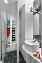 Interior view of a modern bathroom featuring a countertop washbasin and white storage cabinet