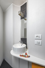 Close-up of a modern countertop washbasin in a minimalist bathroom