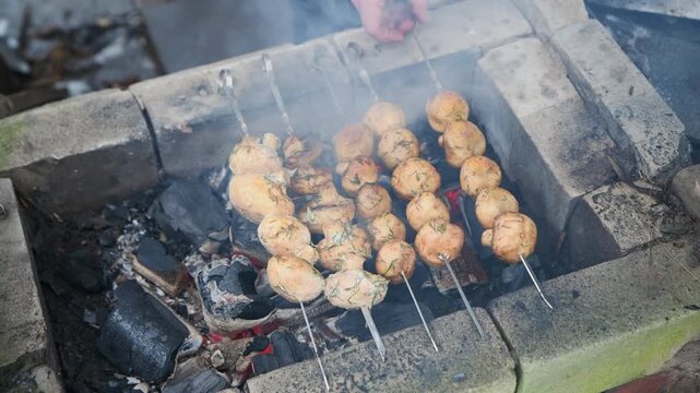 Grilled mushroom kebabs cooking over outdoor charcoal pit