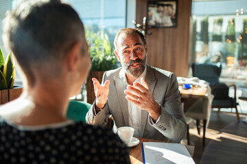 Business consultant advising client in coffee shop