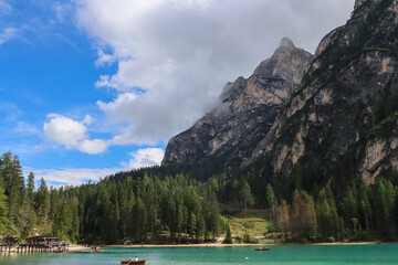 Wooden boats drifting across turquoise alpine waters in Dolomites