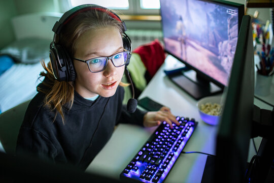 Teen gamer girl playing pc at home