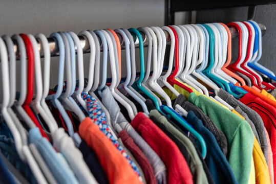 Colorful Assorted Casual Clothes on Plastic Hangers in Neatly Organized Closet