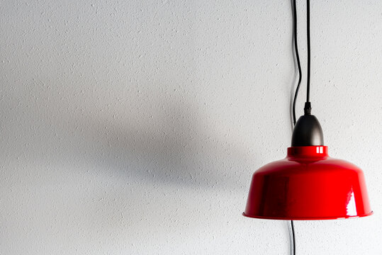 Contemporary Red Pendant Light Fixture Hanging in Front of White Textured Wall