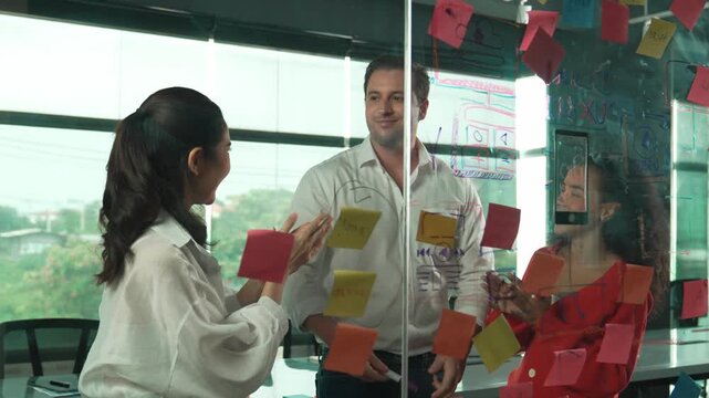 Happy business team celebrate successful project at glass wall. Group of professional diverse business people shaking hand, high five, thumb up at business meeting. Creative business. Manipulator.