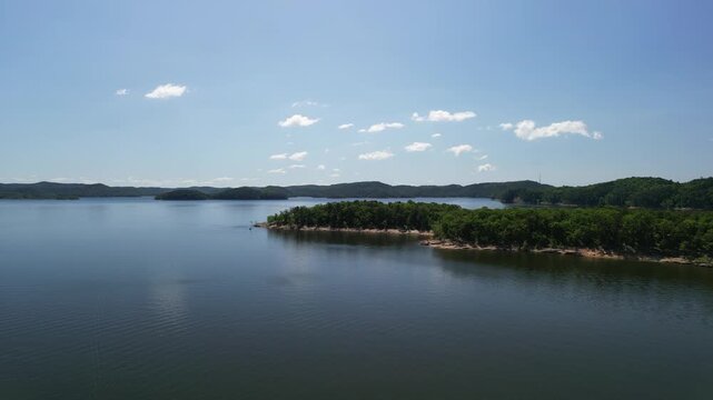 Drone video of lake panorama with islands and forested shore calm water summer landscape slowly flying forward above lake