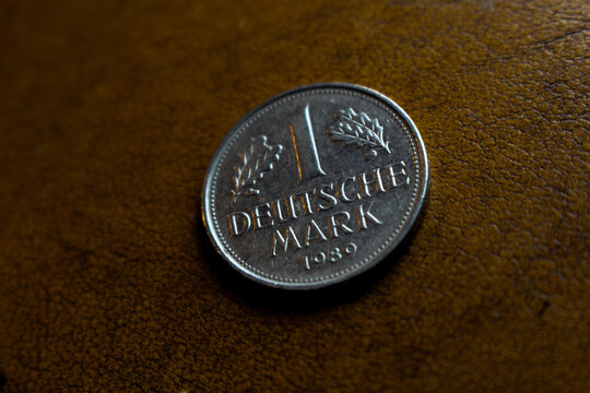 one old shiny silver colored deutschmark coin laying on a wooden underground