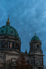 Obraz premium detailed facade and greenish blue cupolas of berlin cathedral berliner dom germany with golden spires on an autumn evening 