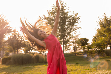 beautiful teenage brunette girl with long hair, smiling, looking at the camera during a summer walk