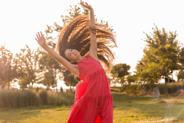 beautiful teenage brunette girl with long hair, smiling, looking at the camera during a summer walk