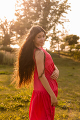 beautiful teenage brunette girl with long hair, smiling, looking at the camera during a summer walk
