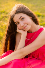 beautiful teenage brunette girl with long hair, smiling, looking at the camera during a summer walk