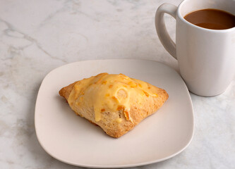 orange scone with a cup of coffee