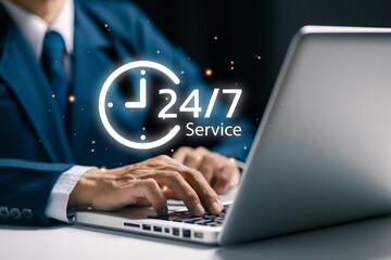 Business professional working on laptop with 24/7 service icon, representing round-the-clock customer support, online assistance, service availability, and continuous business service.