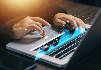 Business professional analyzing financial data with rising graphs on laptop, representing market performance, investment growth, trading analysis, financial forecasting