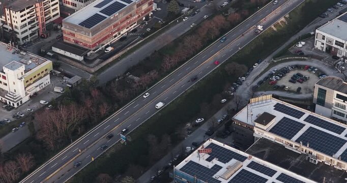 Aerial view of tanning factory buildings with solar panels and a highway bustling with traffic, showcasing the urban landscape, Solofra, Campania, Italy.