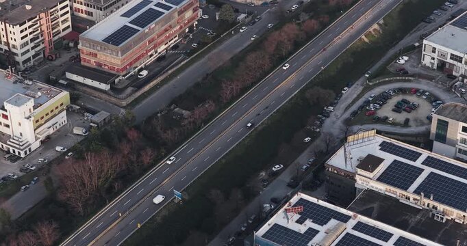 Aerial view of buildings with solar panels and a highway with vehicles creating a contrasting blend of urban infrastructure, Solofra, Campania, Italy.